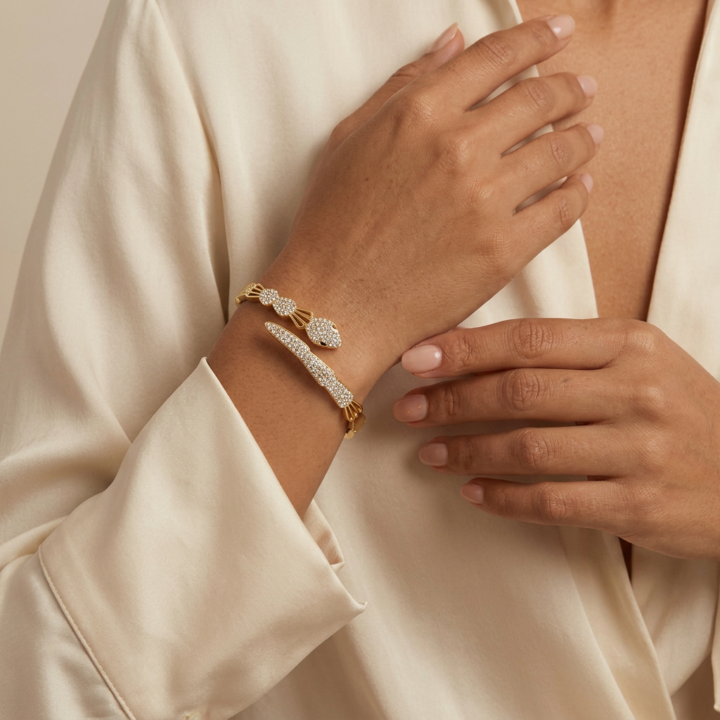 Serpent bangle worn near a cream blouse